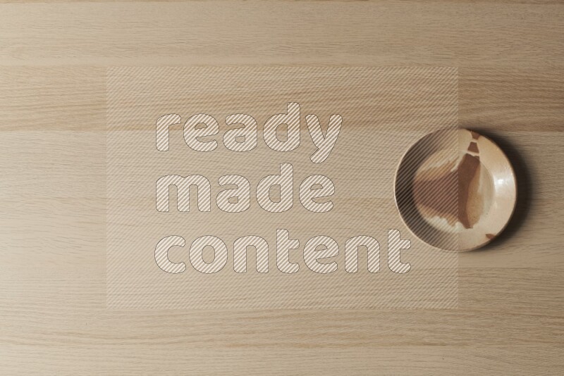 صحن فخاري متعدد الألوان على خلفية خشبية فاتحة