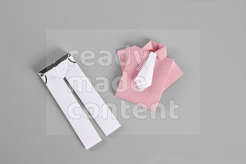 Origami clothes on grey background