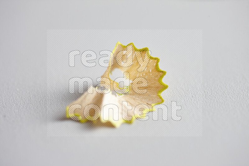 صورة مقربة تظهر كومة صغيرة من نشارة الأقلام ذات حواف ملونة متنوعة علي خلفية رمادية