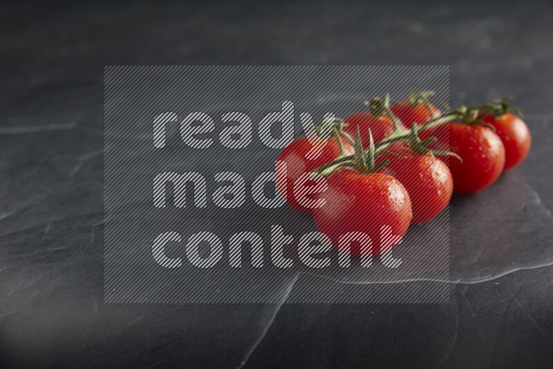 Red cherry tomato vein on a textured black slate background 45 degree