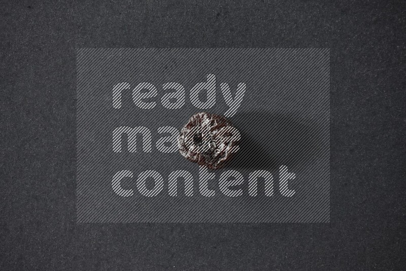 حبة واحدة من البرقوق المجفف على خلفية سوداء