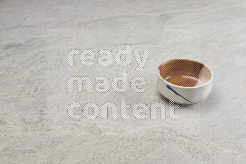 A multicolored pottery bowl on grey marble background