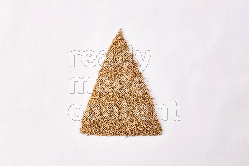 Mustard seeds in a triangle shape on a white flooring