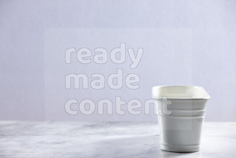 An empty white plant pot on grey marble background
