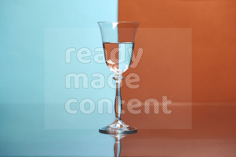 The image features a clear glassware filled with water, set against light blue and dark orange background