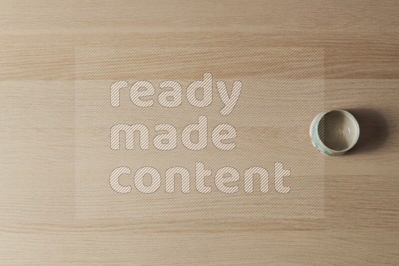 وعاء فخاري متعدد الألوان على خلفية خشبية فاتحة