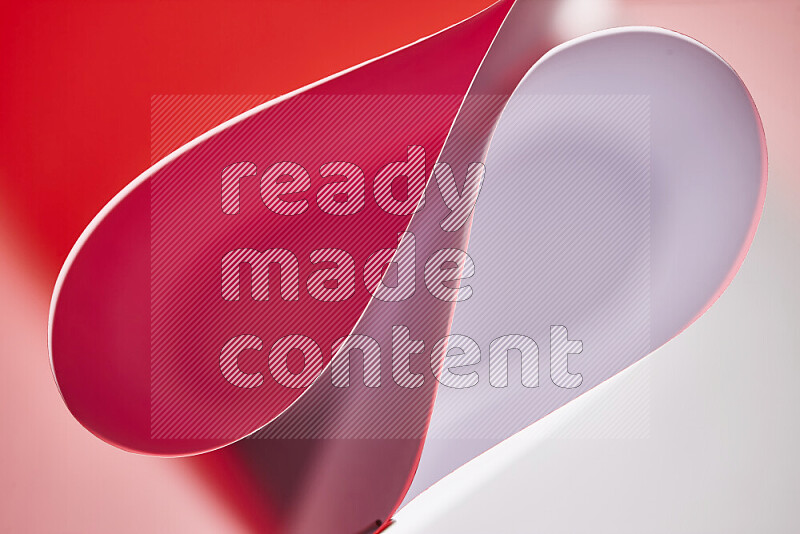 An abstract art of paper folded into smooth curves in white and red gradients