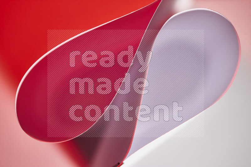 An abstract art of paper folded into smooth curves in white and red gradients