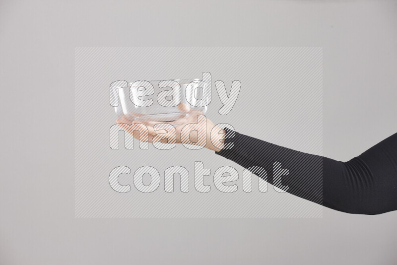 امرأة ترتدي عباءة سوداء تحمل أدوات زجاجية مختلفة في أوضاع متعددة