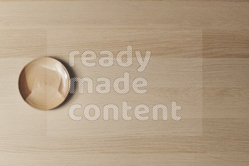 A multicolored pottery plate on light wooden background