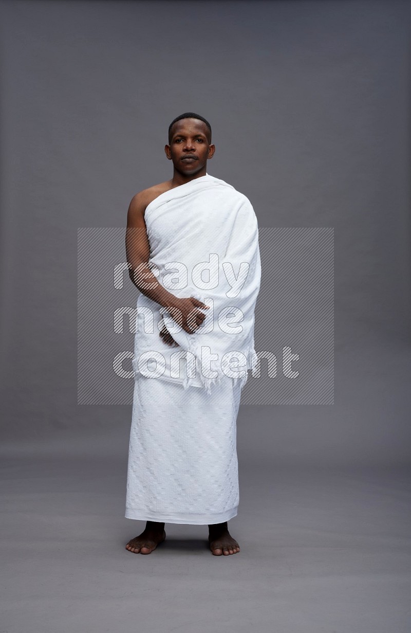 A man wearing Ehram Standing Interacting with the camera on gray background