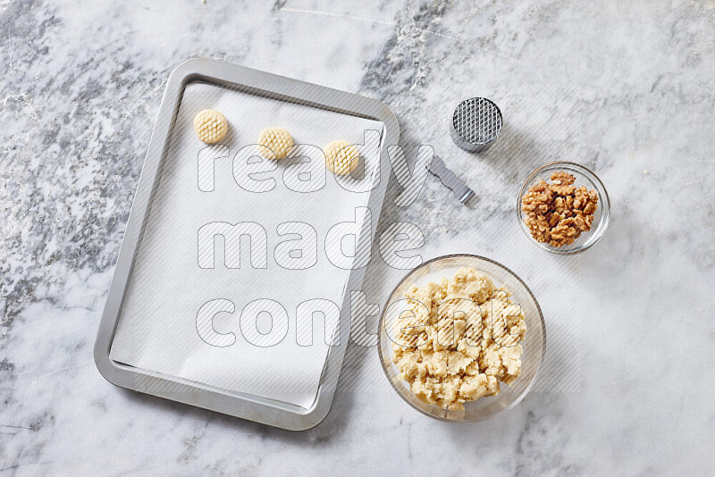 Kahk step by step with its ingredients ghee, sugar, flour, sesame, yeast, water and kahk flavor on grey marble background