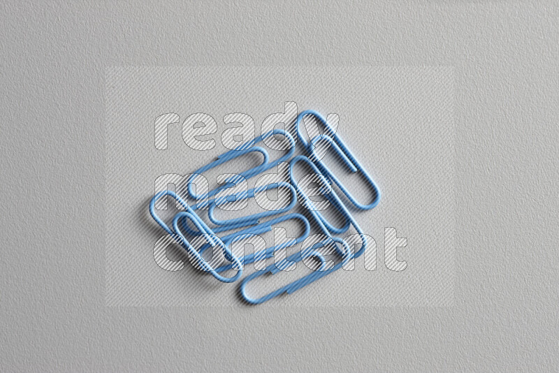 Blue paper clips isolated on a grey background