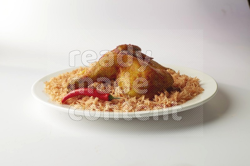 red basmati Rice with kabsa chicken pieces on a white rounded plate direct on white background