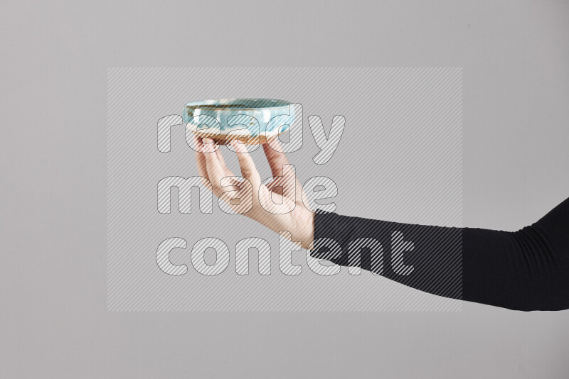 امرأة ترتدي عباءة سوداء تحمل أدوات فخارية مختلفة في أوضاع متعددة