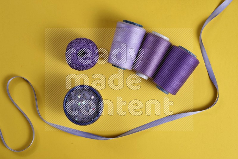 Purple sewing supplies on yellow background