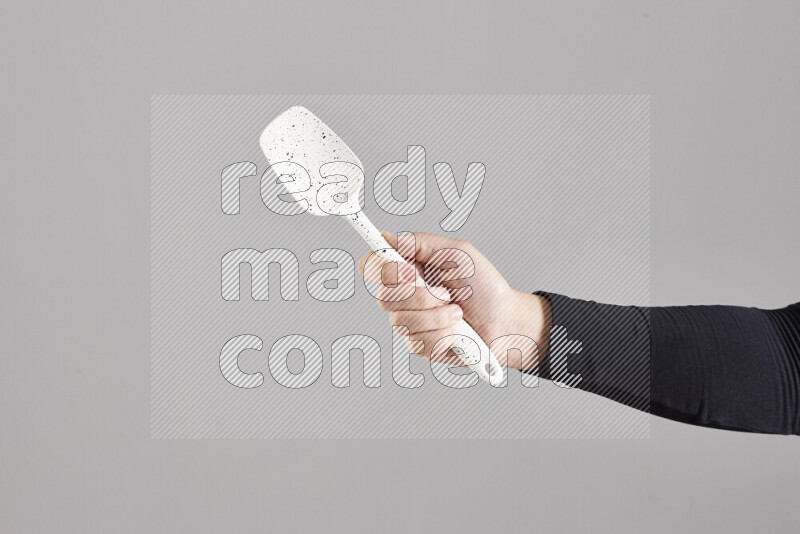A woman in black abaya holding different wooden essentials in different positions