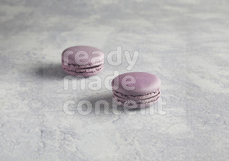 45º Shot of two Purple Blueberry macarons  on white  marble background