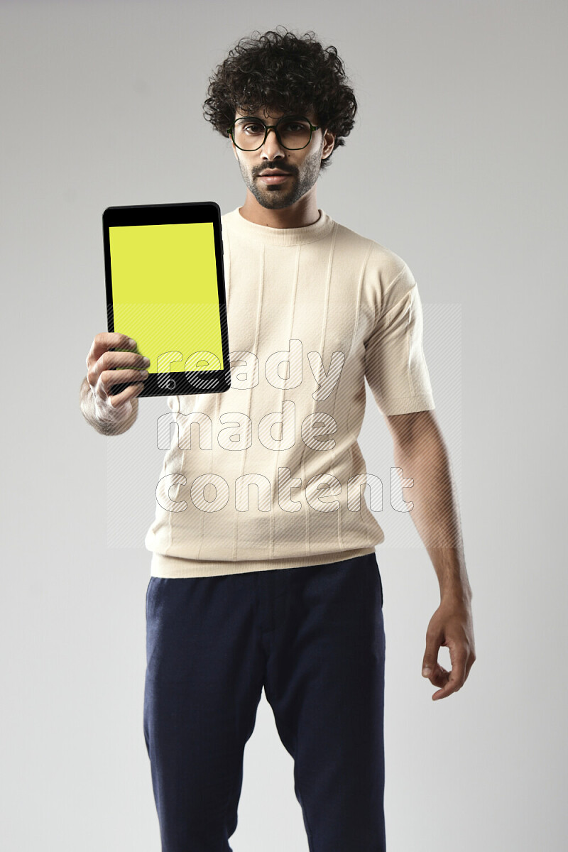 A man wearing casual standing and showing a tablet screen on white background