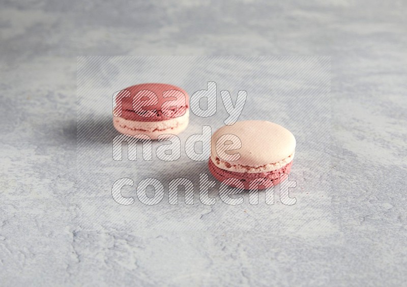 45º Shot of two Pink Litchi Raspberry macarons  on white  marble background