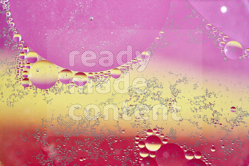 Close-ups of abstract oil bubbles on water surface in shades of yellow and pink