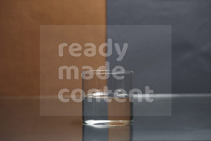 The image features a clear glassware filled with water, set against brown and dark blue background