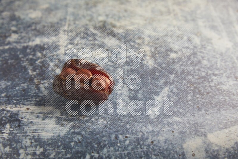 hazelnuts stuffed majdoul date on a rustic blue background