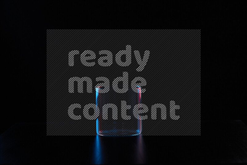 Glassware with rim light in red and blue against black background