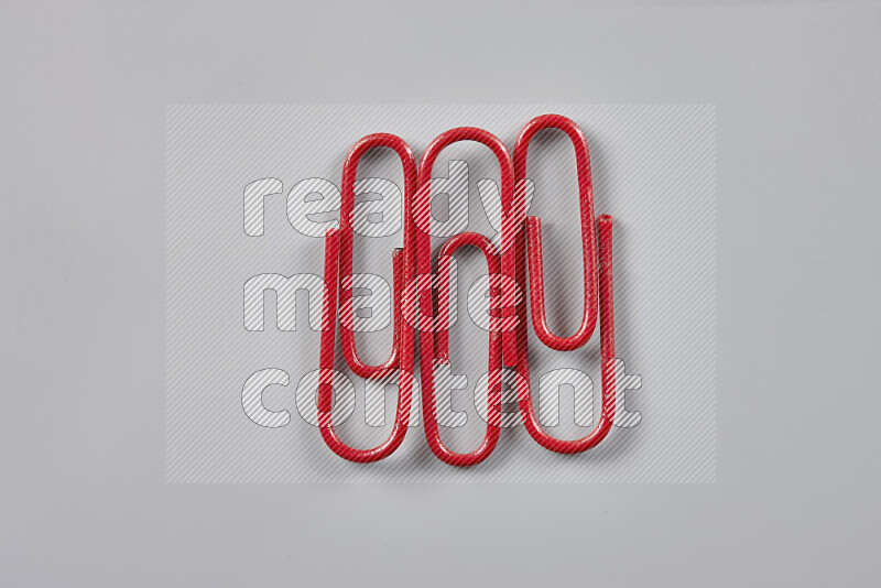 Red paperclips isolated on a grey background