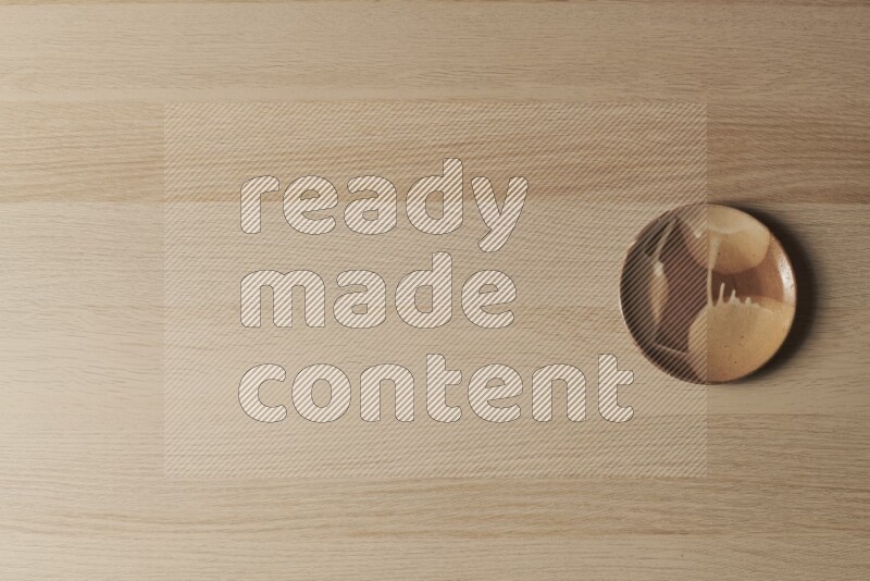 صحن فخاري متعدد الألوان على خلفية خشبية فاتحة