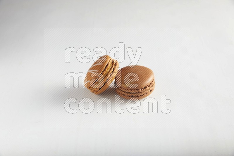 45º Shot of of two assorted Brown Irish Cream, and Brown Coffee macarons  on white background