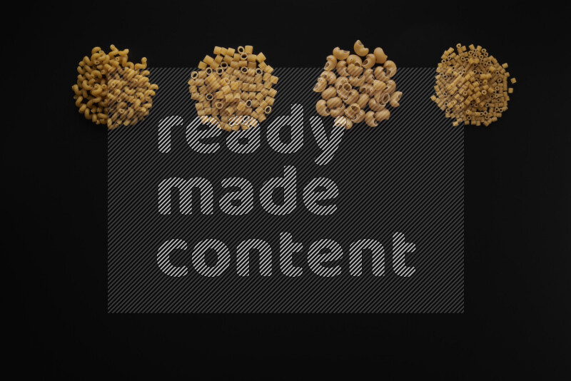 Different pasta types in 4 bunches on black background