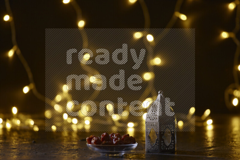 A traditional ramadan lantern surrounded by glowing fairy lights in a dark setup