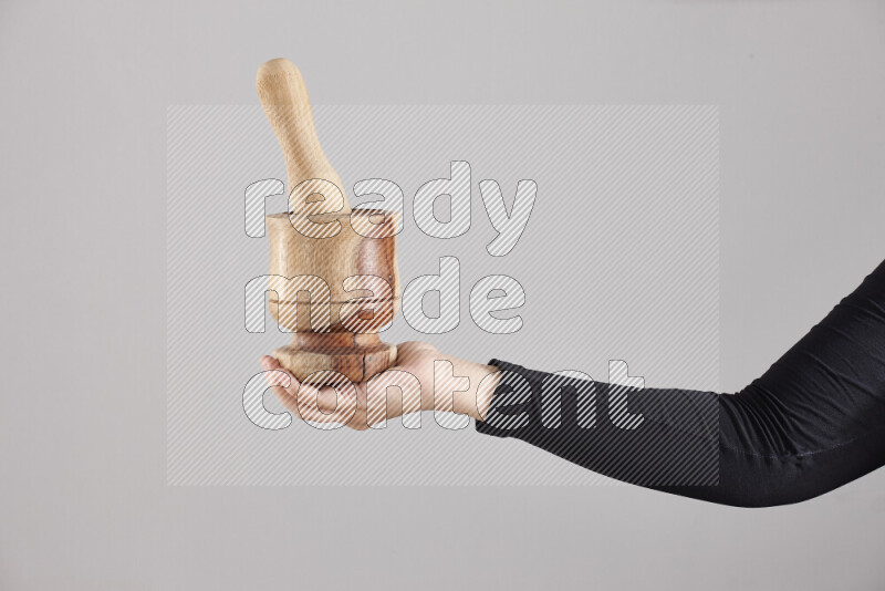 A woman in black abaya holding different wooden essentials in different positions