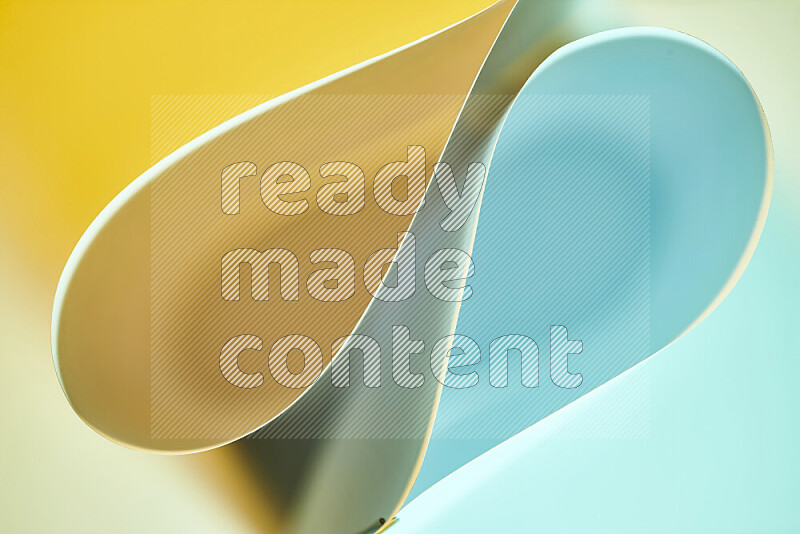 An abstract art of paper folded into smooth curves in blue and yellow gradients