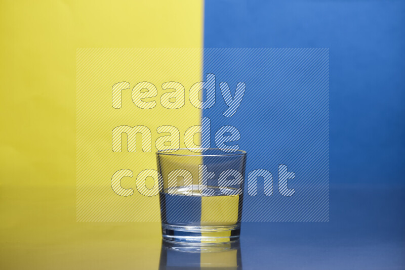 The image features a clear glassware filled with water, set against yellow and blue background