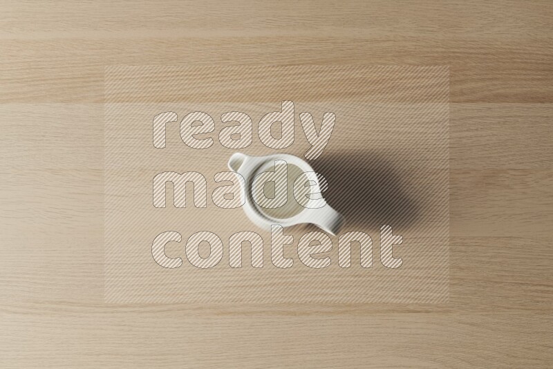 A ceramic milk jug on light wooden background