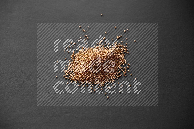 Mustard seeds on a black flooring