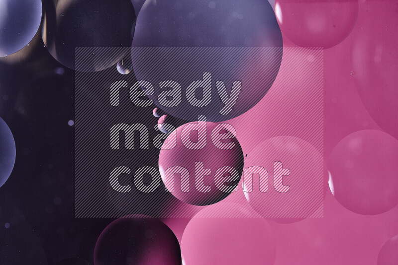 Close-ups of abstract oil bubbles on water surface in shades of black and pink