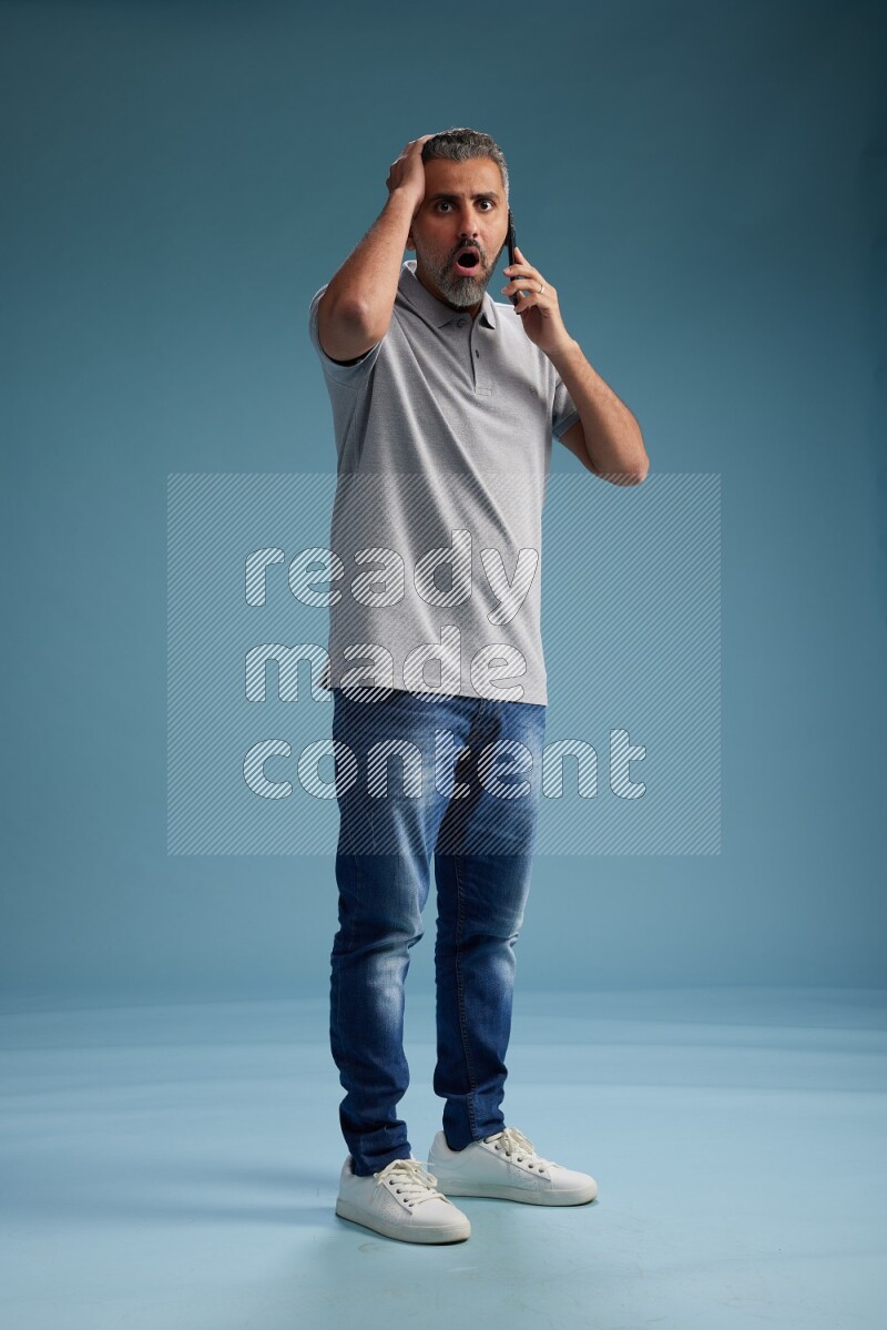 Man Standing talking on phone on blue background
