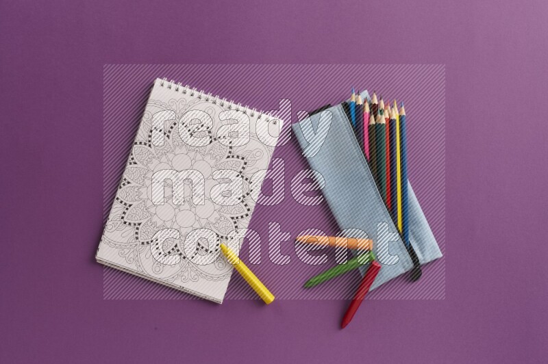 A coloring book with coloring pens on purple background