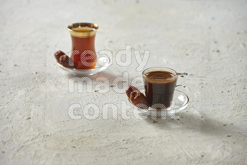 A coffee glass cup with dates and tea on textured white background