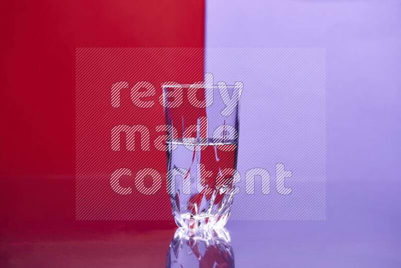 The image features a clear glassware filled with water, set against red and light purple background