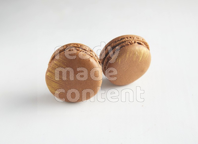 45º Shot of two Brown Coffee macarons on white background