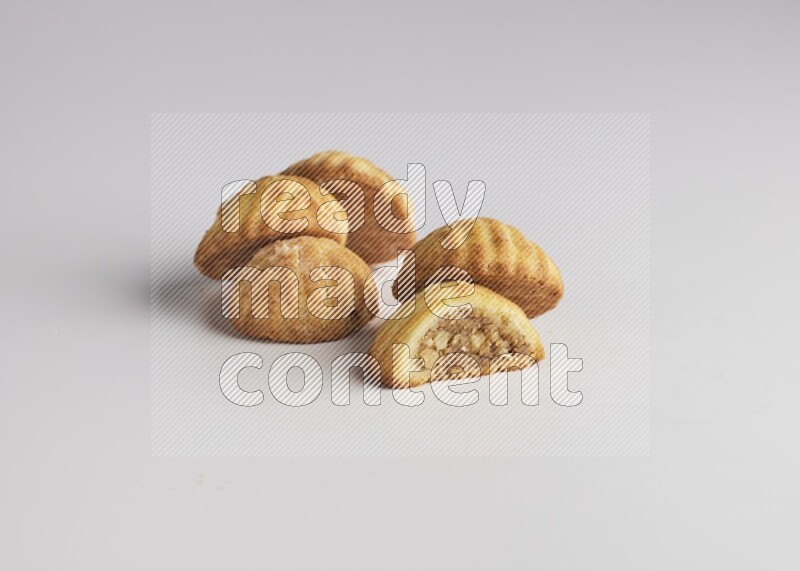 Five Pieces of Maamoul filled with walnut paste  one of them is cut with direct on white background