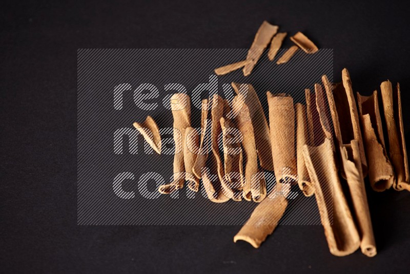 Cracked cinnamon sticks on a black background