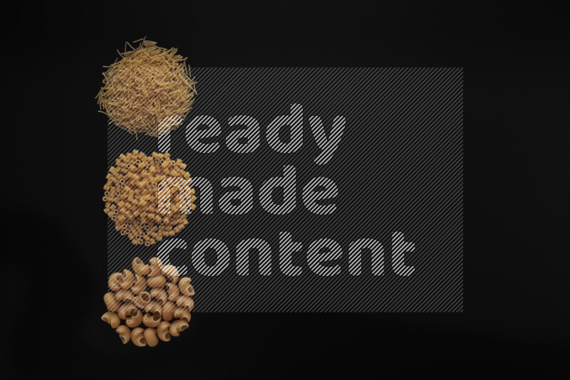 Different pasta types in 3 bunches on black background