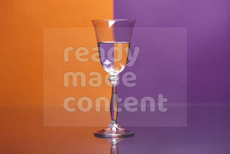 تظهر الصورة أواني زجاجية ممتلئة بالماء موضوعة على خلفية من اللونين البرتقالي والأرجواني