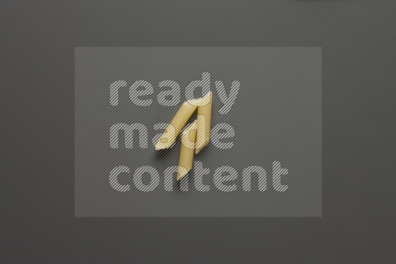 Mini penne pasta on grey background