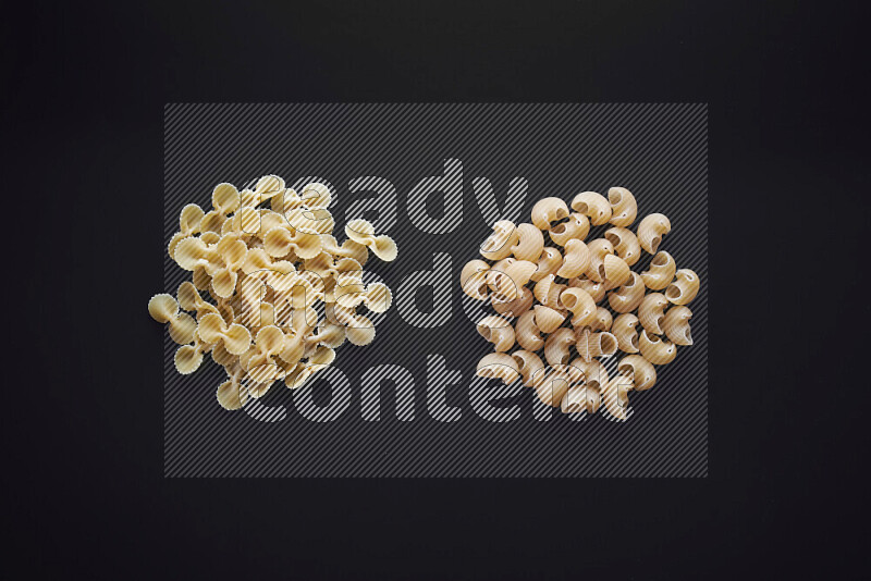 Different pasta types in bunches on black background